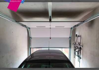 Motoros szekcionált garázskapu fehér színben, 2 ablakkal Ravazdon